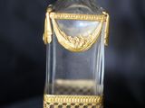une bouteille en verre à l'ancienne, ornée d'une bordure dorée et d'une poignée dorée
