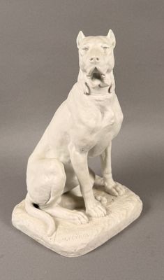 statue d'un chien blanc assis sur un coussin, la gueule ouverte