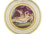 une assiette sur laquelle est représentée une femme allongée sur un lit