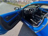 une voiture bleue dont la portière est ouverte dans la rue