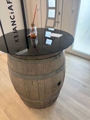 a table made out of a wine barrel with a bottle on top