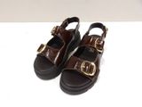 brown leather sandals with gold buckles on the toes