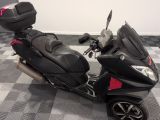 un scooter noir et rouge garé sur un sol à damier