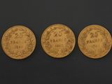 three gold coins, one of which has a date and the other has a date on it