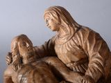 a wooden statue of a woman holding a child