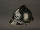 a silver helmet with a lion on it sitting on a stand