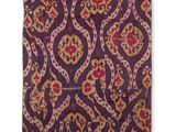 un gros plan sur un coussin violet et rouge orné d'un motif