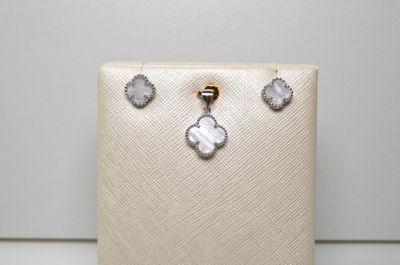 un gros plan sur un sac à main blanc sur lequel sont posées une paire de boucles d'oreilles