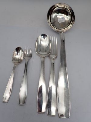 five silver spoons and a bowl on a table