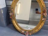 un miroir posé par terre près d'un mur