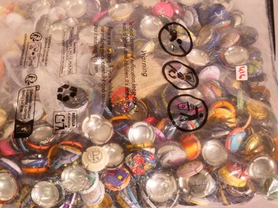a bag full of buttons and magnets sitting on a table
