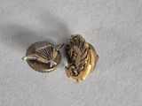 a close up of two gold buttons on a white surface