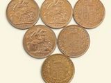 Six pièces de monnaie britanniques sont disposées en triangle sur une surface blanche
