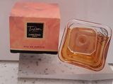 un flacon de parfum posé sur une boîte