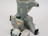 a small elephant figurine sitting on the ground next to a computer mouse