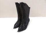 pair of black high heeled boots sitting on top of a white table