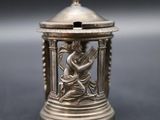 an antique silver figurine of a woman playing the harp