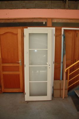 a glass door in the middle of a room with wooden cabinets