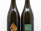 deux bouteilles de vin posées l'une à côté de l'autre sur une surface blanche