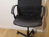 a black office chair that is sitting on a hard wood floor