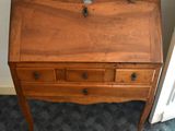 a small wooden desk with a drawer on top of it