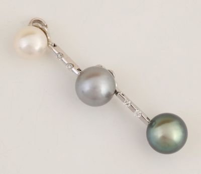 un gros plan sur une paire de boucles d'oreilles en perles posées sur une surface blanche