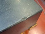a small black box on a wooden stand on a red floor