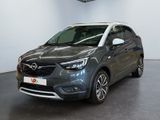 a grey opel is parked in a large room