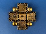 a close up of a gold cross on a blue surface