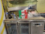 une cuisine équipée d'un réfrigérateur et d'un plan de travail sur lequel sont disposés de nombreux aliments