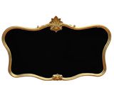 un miroir à cadre noir et doré, avec un cadre doré