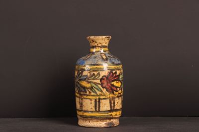 a small vase with a painting on it sitting on a table