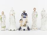 five figurines of different sizes and colors on a white surface