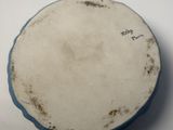 an old blue and white plate sitting on top of a white table