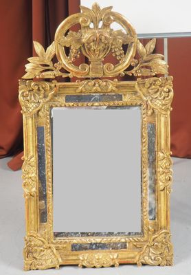 un miroir avec un cadre doré posé sur une table