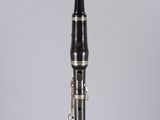 an image of a black and silver clarinet on a clear surface