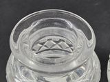 pair of clear glass salt and pepper shakers on a black surface