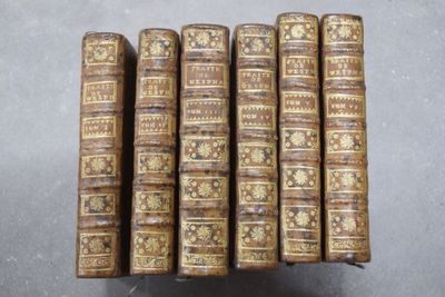 six vieux livres sont empilés sur une table