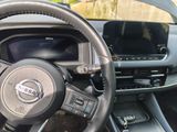 a steering wheel and dashboard of a car with a monitor