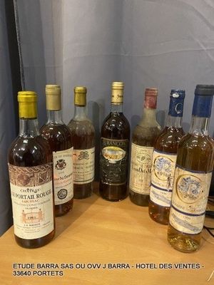 several bottles of wine are lined up on a wooden table