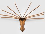 une image représentant une sculpture en bois représentant une tête de cheval d'où sortent des bâtons