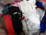 a pile of clothes in a basket on a bed