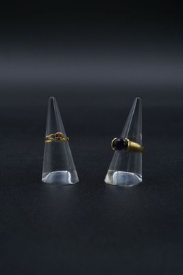 deux cônes transparents ornés d'anneaux dorés, posés sur une surface noire