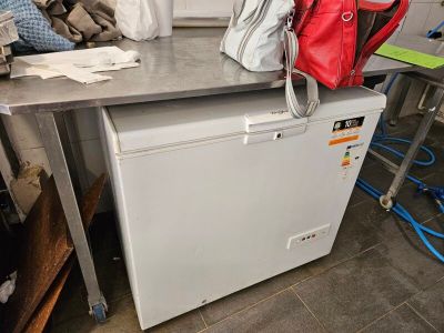 a red bag sitting on top of a white refrigerator