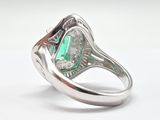 an image of a ring with a green stone surrounded by diamonds