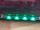 a red vacuum that is on the floor with green lights