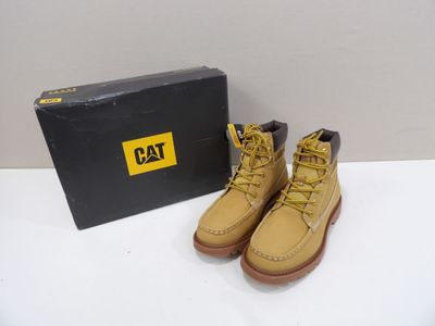 yellow boots with yellow laces and a black box on a white surface