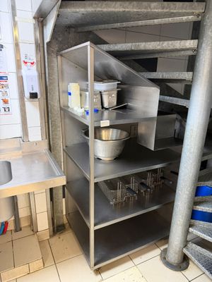 a kitchen with stainless steel shelvings and a sink