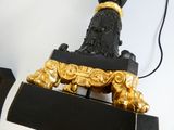 a black and gold statue of a dog on a black stand