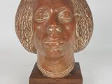 an image of a sculpture of a woman ' s head on a wooden base